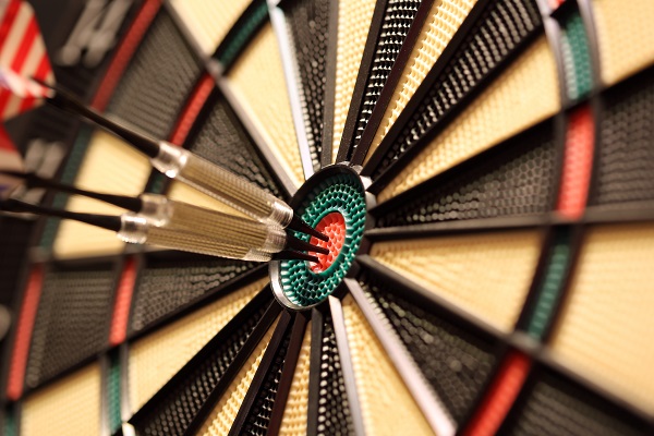 EMC photo of dart board with three darts in the center bullseye circle