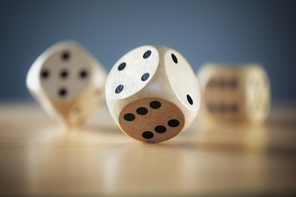 EMC photo of three wooden dice rolling