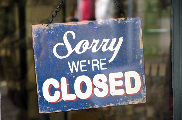 EMC photo of a store window with a sign saying, "Sorry we're closed"