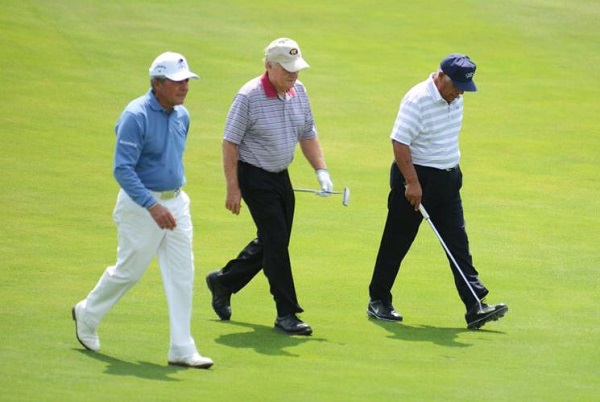 Three golfers walking on golf course 